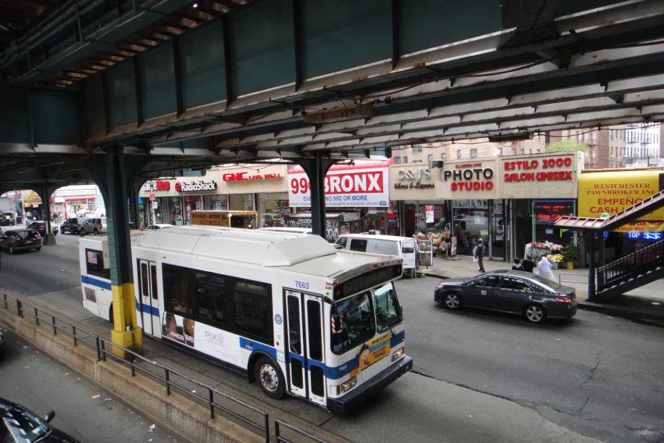 A New York MTA drives down the straight under elevated train tracks in the Bronx in New York City